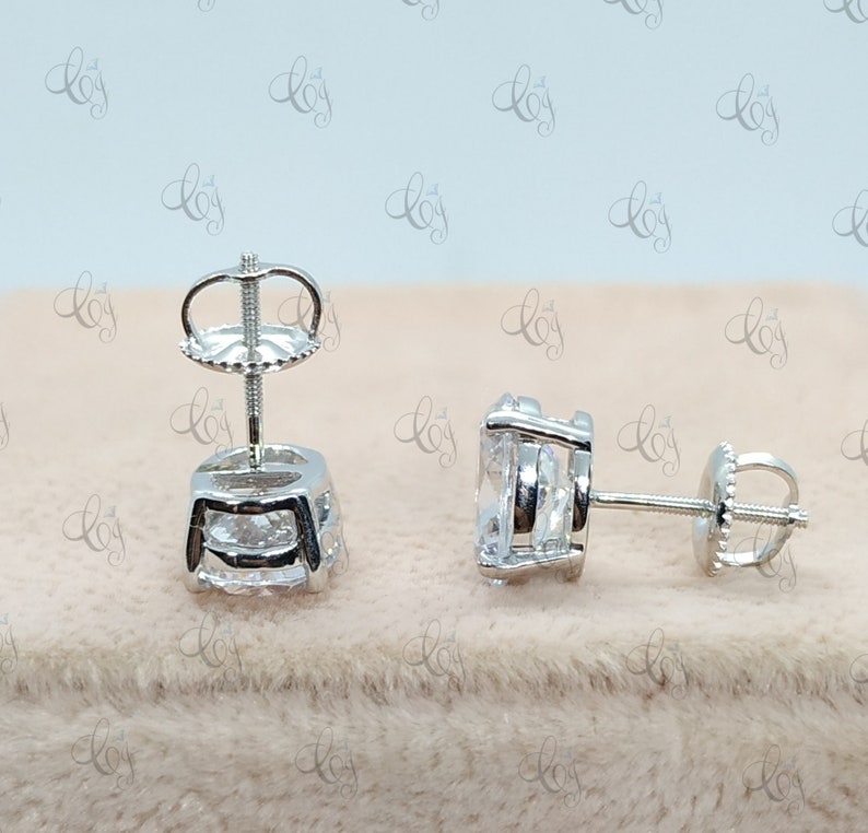May include: A pair of silver stud earrings with clear cubic zirconia stones. The earrings have a simple, elegant design and are perfect for everyday wear.