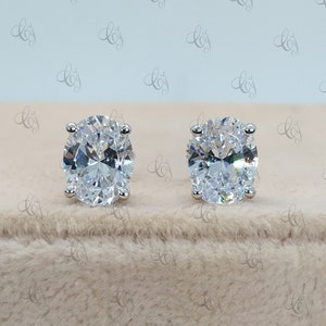 May include: A pair of silver stud earrings with large oval-shaped clear cubic zirconia stones.