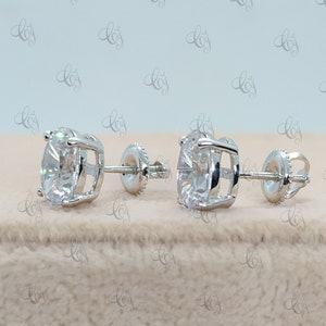 May include: A pair of silver stud earrings with a large, round, clear gemstone in the center of each earring.