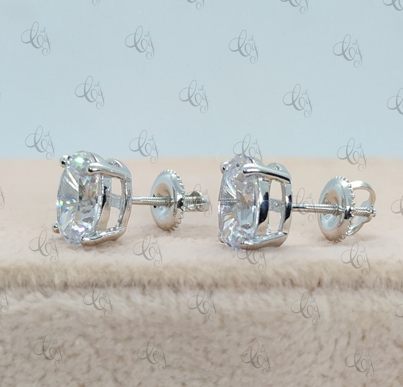 May include: A pair of silver stud earrings with a large, round, clear gemstone in the center of each earring.