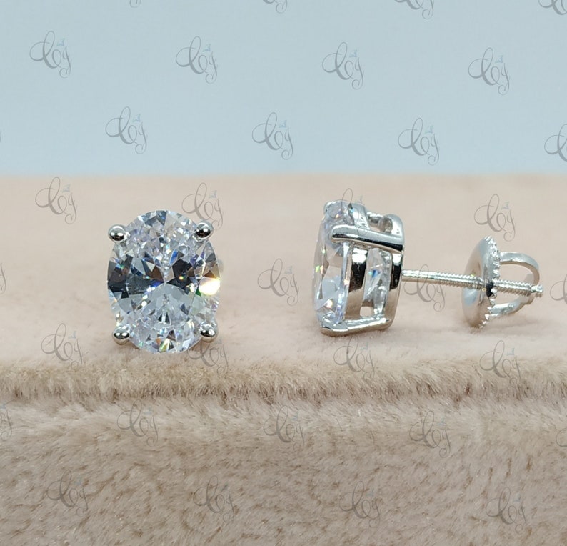May include: A pair of silver stud earrings with large oval-shaped clear cubic zirconia stones.