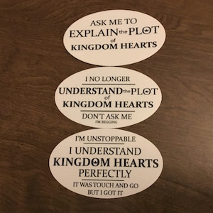 May include: Three white oval stickers with black text related to the video game Kingdom Hearts. The top sticker reads "Ask me to explain the plot of Kingdom Hearts." The middle sticker says "I no longer understand the plot of Kingdom Hearts. Don't ask me, I'm begging." The bottom sticker says "I'm unstoppable, I understand Kingdom Hearts perfectly. It was touch and go but I got it."