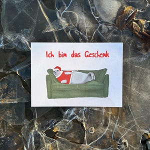 Carte postale de Noël « Je suis le cadeau ». Joint. Noël . canapé. ne donne rien. Estime de soi. Personne préférée.