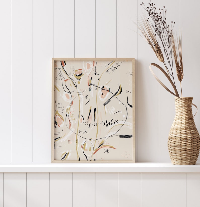 May include: Abstract art print with black, white, pink, and green lines and shapes on a beige background. The print is framed in a light wood frame.