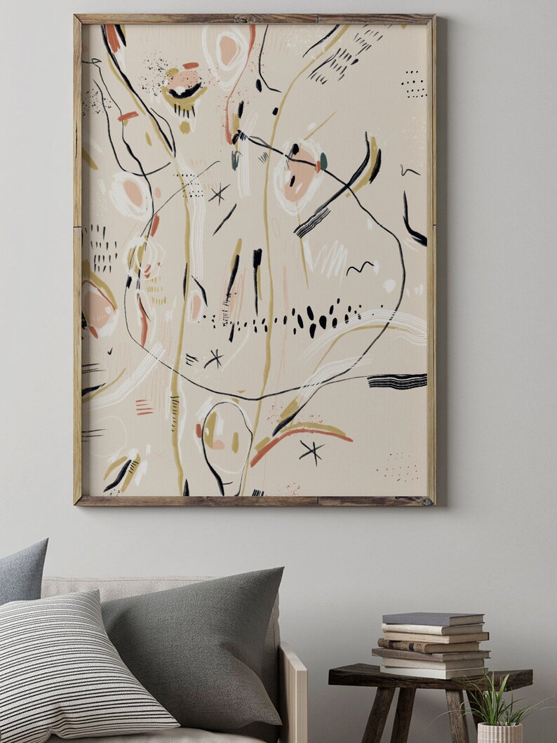 May include: Abstract art print in a wooden frame. The print features a beige background with black, white, pink, and gold lines and shapes.