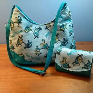 May include: A teal blue and white fabric tote bag and matching wallet with a repeating pattern of turtles and the text "Grateful Dead".