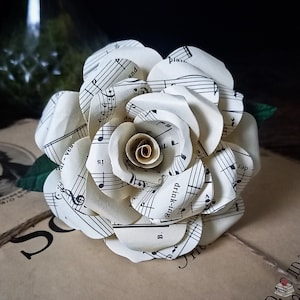 Bladmuziekpapieren roos met groene bladeren en label met cadeaubericht