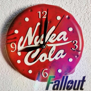 May include: A red and white clock with the words "Nuka Cola" on the face. The clock is shaped like a bottle cap and has a distressed look. The clock hands are black and point to the numbers 12 and 3.