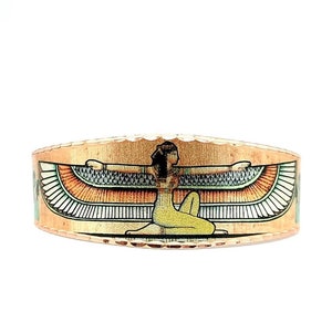 May include: Copper ring with an image of the Egyptian goddess Isis with outstretched wings. The ring is a warm copper color with a textured surface.