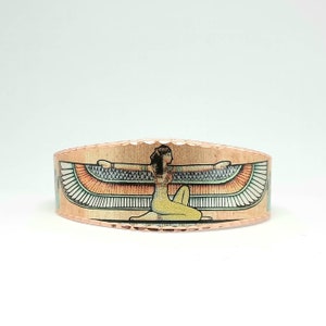May include: A copper bracelet with a colorful image of the Egyptian goddess Isis with outstretched wings.