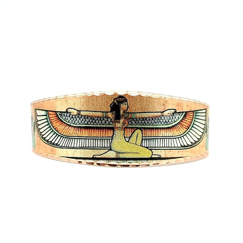 May include: Copper ring with an image of the Egyptian goddess Isis with outstretched wings. The ring is a warm copper color with a textured surface.