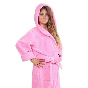 May include: A pink hooded bathrobe with a tie belt. The robe is made of soft, plush fabric.