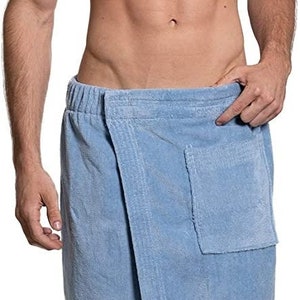 May include: A light blue terry towelling wrap featuring an elasticated waistband, a wrap-around front closure, and a single patch pocket on the right side. The fabric has a textured, absorbent surface typical of bath linens, designed for comfort.