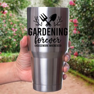 May include: Stainless steel tumbler with a black graphic of gardening tools and the text "GARDENING forever (HOUSEWORK WHENEVER)"