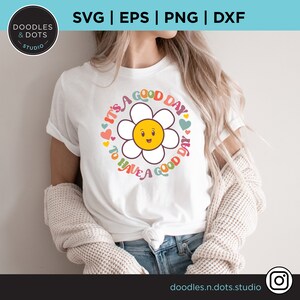 May include: White t-shirt with a colorful daisy graphic and the text "It's a good day to have a good day".