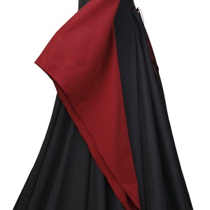 Puede incluir: Un vestido de estilo medieval negro y burdeos con mangas largas y lazada en la espalda.