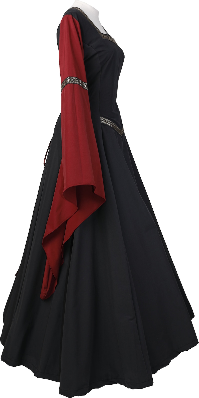 Puede incluir: Un vestido negro de estilo medieval con mangas largas. Las mangas son rojas y tienen un ribete dorado. El vestido tiene un corpi&ntilde;o ajustado y una falda fluida.
