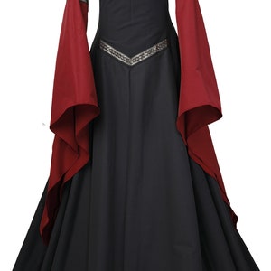Puede incluir: Un vestido negro de estilo medieval con mangas largas rojas y ribetes dorados. El vestido tiene un escote cuadrado y una falda fluida.