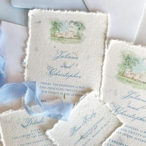 Könnte beinhalten: Eine Sammlung handgefertigter Hochzeitseinladungen und -karten. Die Einladungen zeigen eine Aquarellillustration eines Gebäudes und eine elegante Schrift. Das Set umfasst Einladungskarten, Antwortkarten und Detailkarten, alle mit zerrissenen Kanten und hellblauen Akzenten.