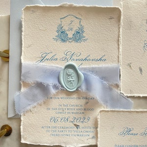 Set di inviti di nozze fatti a mano blu polveroso, inviti di carta con bordo increspato, fiori di carta di cotone, piante, sigilli di cera, nastro strappato