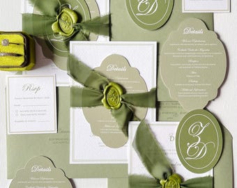 May include: An olive green wedding stationery set featuring invitation cards, RSVP cards, and envelopes, all tied with a green ribbon. The set includes a wax seal and a velvet ring box. The word "Details" is printed on the cards.