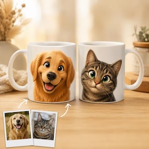 Può includere: Due tazze in ceramica bianca con illustrazioni di cani e gatti. Una tazza presenta un golden retriever sorridente, l'altra un gatto tigrato. Le tazze sono su una superficie di legno.