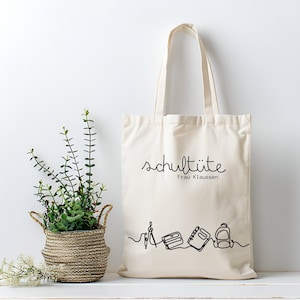 Naturfarbene Baumwolltasche mit Aufdruck schultüte und dem Namen der Lehrkraft, mit einer Illustration von Schul-, oder Berufsutensilien, wie Notizheft und Rucksack. Personalisierte Tasche.