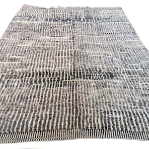 May include: A black and white patterned rug with a geometric design. The rug has a subtle sheen and a soft texture.