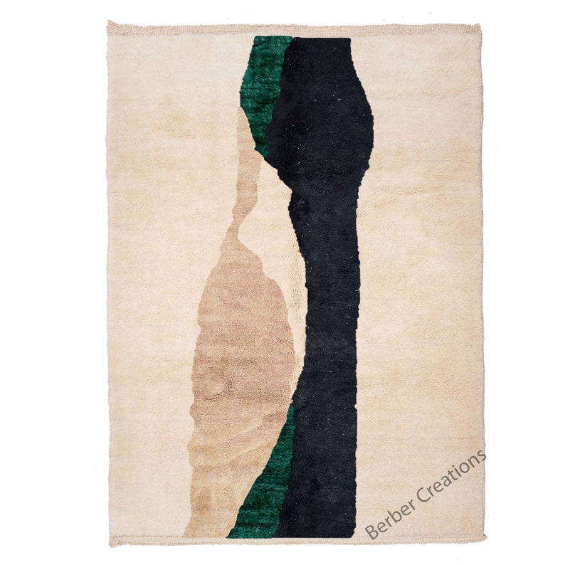 Pu&ograve; includere: Un tappeto beige con un designo astratto in nero e verde. Il tappeto ha un bordo a frangia e il testo "Berber Creations" &egrave; stampato nell'angolo in basso a destra.