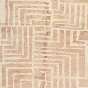 Puede incluir: Una alfombra beige con un patr&oacute;n geom&eacute;trico de l&iacute;neas blancas que forman cuadrados y rect&aacute;ngulos.