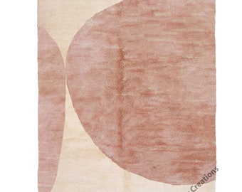 Könnte beinhalten: Ein beiger Teppich mit zwei großen, sich überlappenden rosa Kreisen. Der Teppich hat einen Fransenrand und der Text "Berber Creations" ist in der rechten unteren Ecke gedruckt.