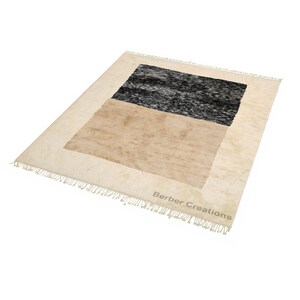 May include: A beige and black geometric rug with a fringe border. The rug has a simple design with two squares, one beige and one black. The rug is made by Berber Creations.