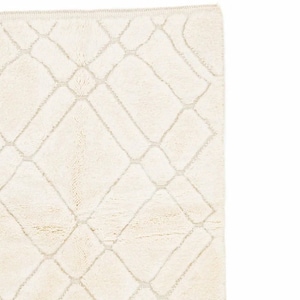 May include: A white rug with a diamond pattern woven into the fabric. The rug has a subtle sheen and a soft, plush texture.