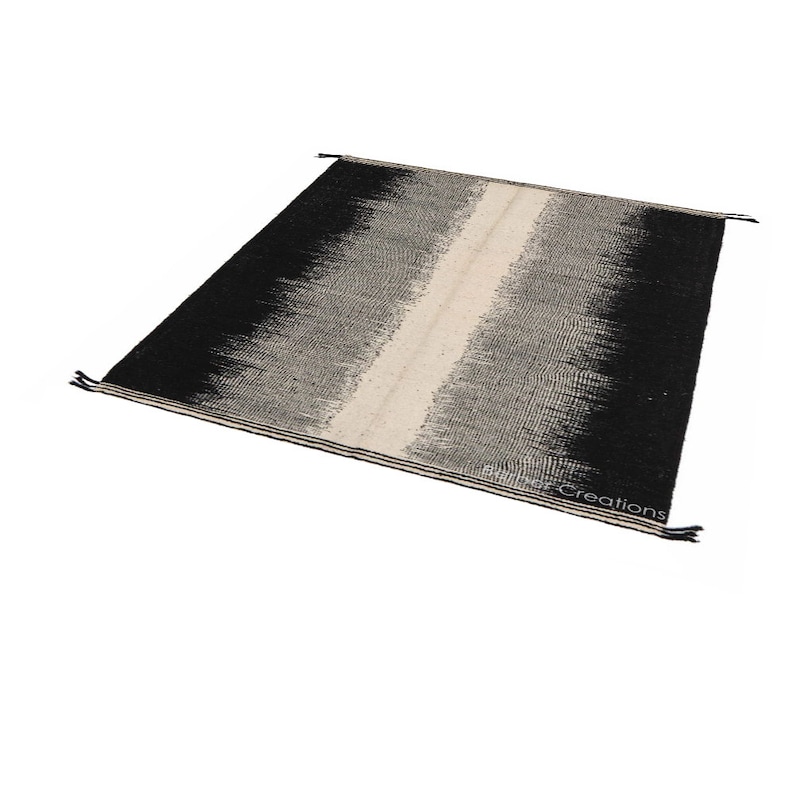May include: Black and white handwoven rug with a vertical stripe down the centre. The rug has a gradient pattern with the black colour fading into white.