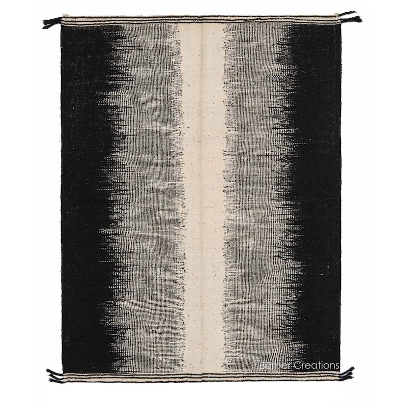 May include: Black and white handwoven rug with a vertical white stripe in the centre. The rug has a gradient pattern, fading from black to white.