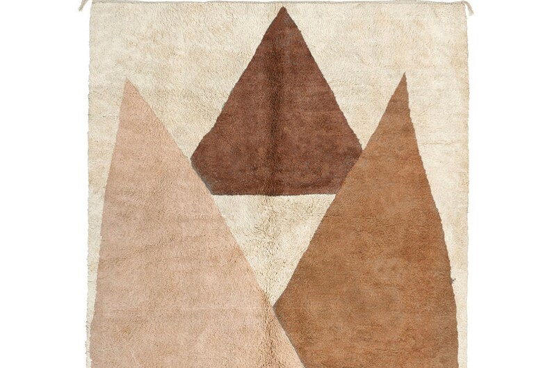Puede incluir: Una alfombra blanca con un dise&ntilde;o geom&eacute;trico de tres tri&aacute;ngulos en tonos marrones y beige.