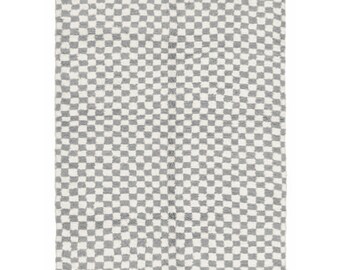 May include: A white and gray checkered rug with a fringe border. The rug is made of wool and has a traditional Moroccan design.