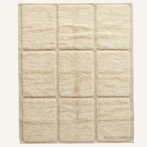 May include: Cream-colored rectangular rug with nine square sections. The sections have a shaggy texture, and the rug has a neutral color palette. The bottom right corner of the rug has the text "Berber Creations".