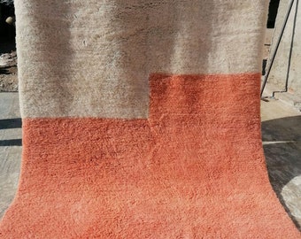 Könnte beinhalten: Ein großer, rechteckiger Teppich mit einer weißen oberen Hälfte und einer pfirsichfarbenen unteren Hälfte. Der Teppich besteht aus einem weichen, flauschigen Material und hat einen Fransenrand.