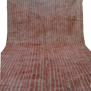 May include: A pink and white striped rug with a fringed border. The rug is made of wool and has a soft, plush texture.