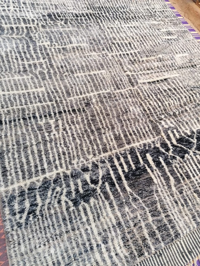 May include: A black and white patterned rug with a geometric design. The rug is made of wool and has a soft, plush texture.