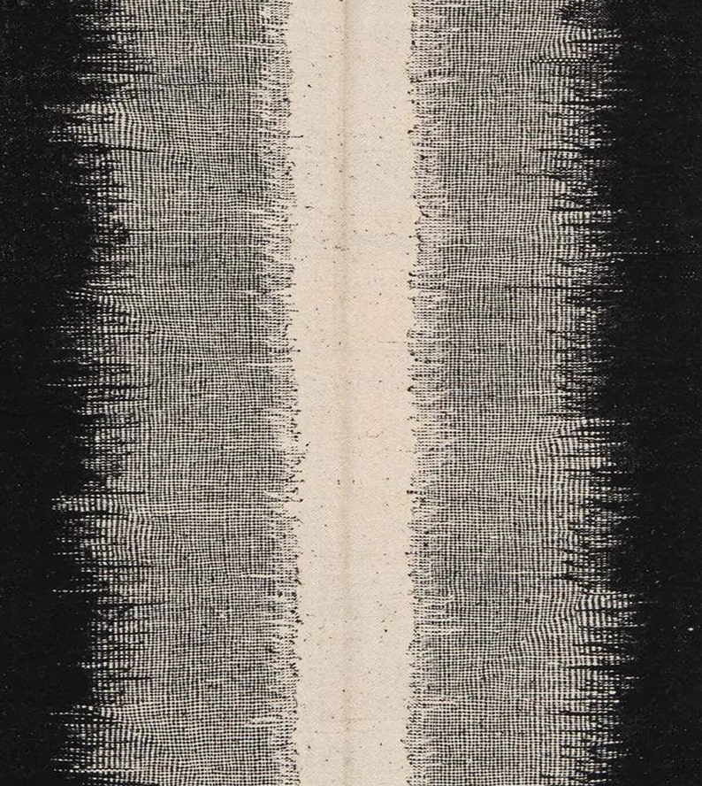 May include: A black and white abstract textile with a vertical white stripe down the centre. The textile has a woven texture.