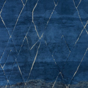 May include: A blue rug with a geometric pattern of white lines. The rug has a gradient effect, with the blue color becoming lighter towards the bottom.