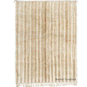 May include: A cream-colored rug with a vertical striped pattern in a slightly darker shade of cream. The rug has a fringe border.