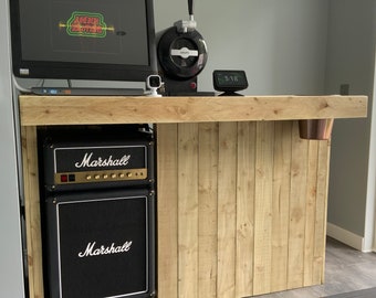May include: A wooden bar counter with a black Marshall amplifier, a computer monitor, and a small black tap system. The bar counter has a wooden top and a wooden front with vertical slats.