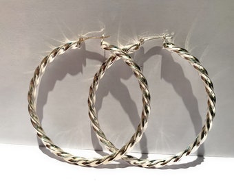 May include: A pair of silver hoop earrings with a twisted design.