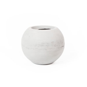 May include: A white round ceramic planter with a smooth, slightly textured surface.