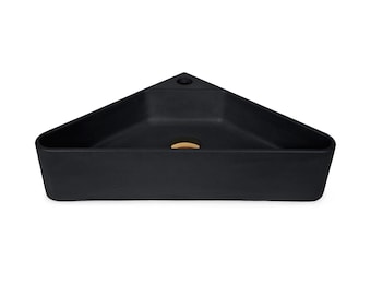 May include: A black triangular ceramic sink with a gold drain.