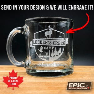 May include: A clear glass mug with a handle, featuring a laser-etched design of a deer, trees, and the text "LEEDER'S CREEK CAMP".