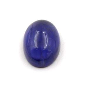 Op de afbeelding: Een diepblauwe ovale cabochon edelsteen met een glad, gepolijst oppervlak.